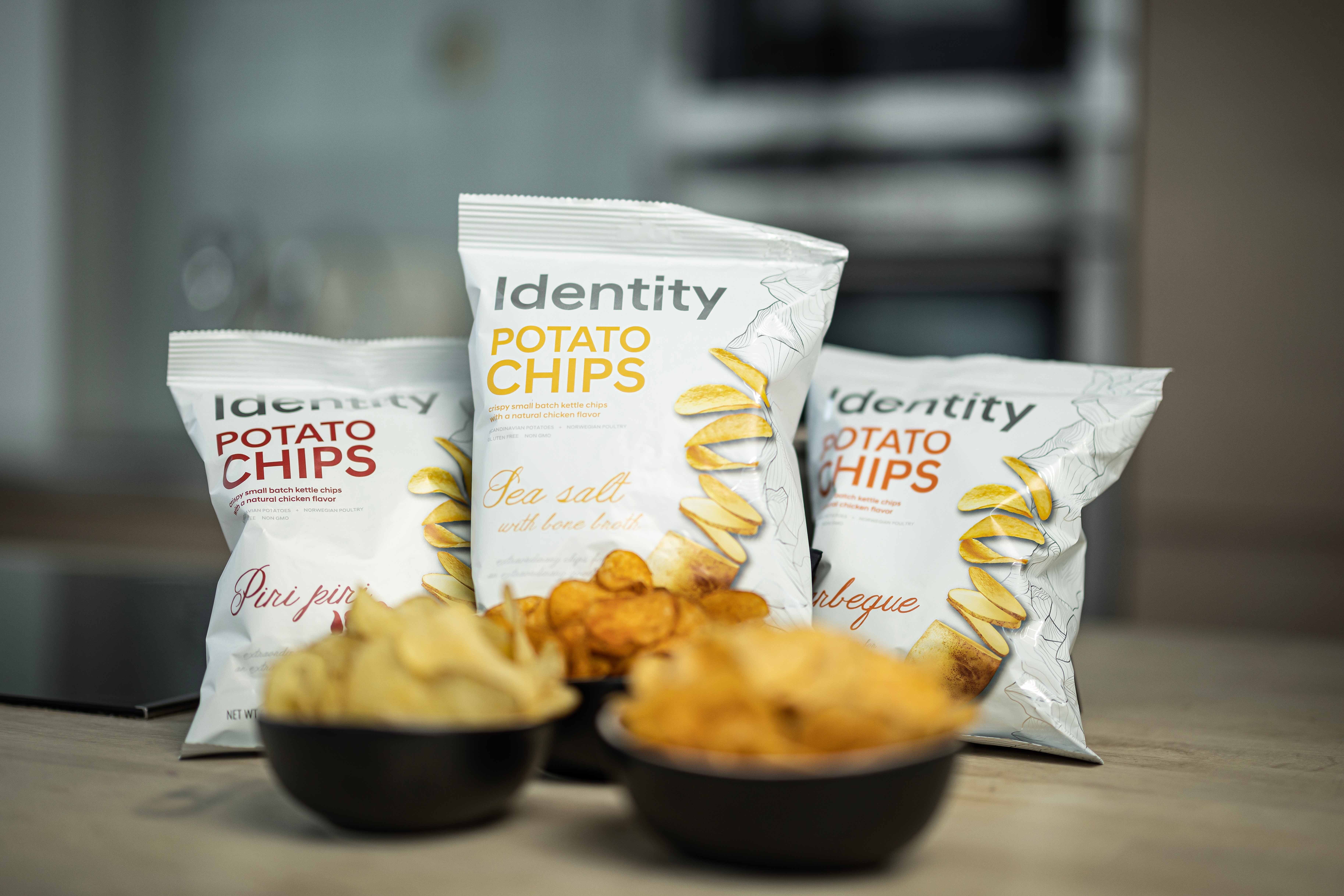 Three white bags of potato crisps in different flavours – piri piri, barbeque, and sea salt and bone broth.