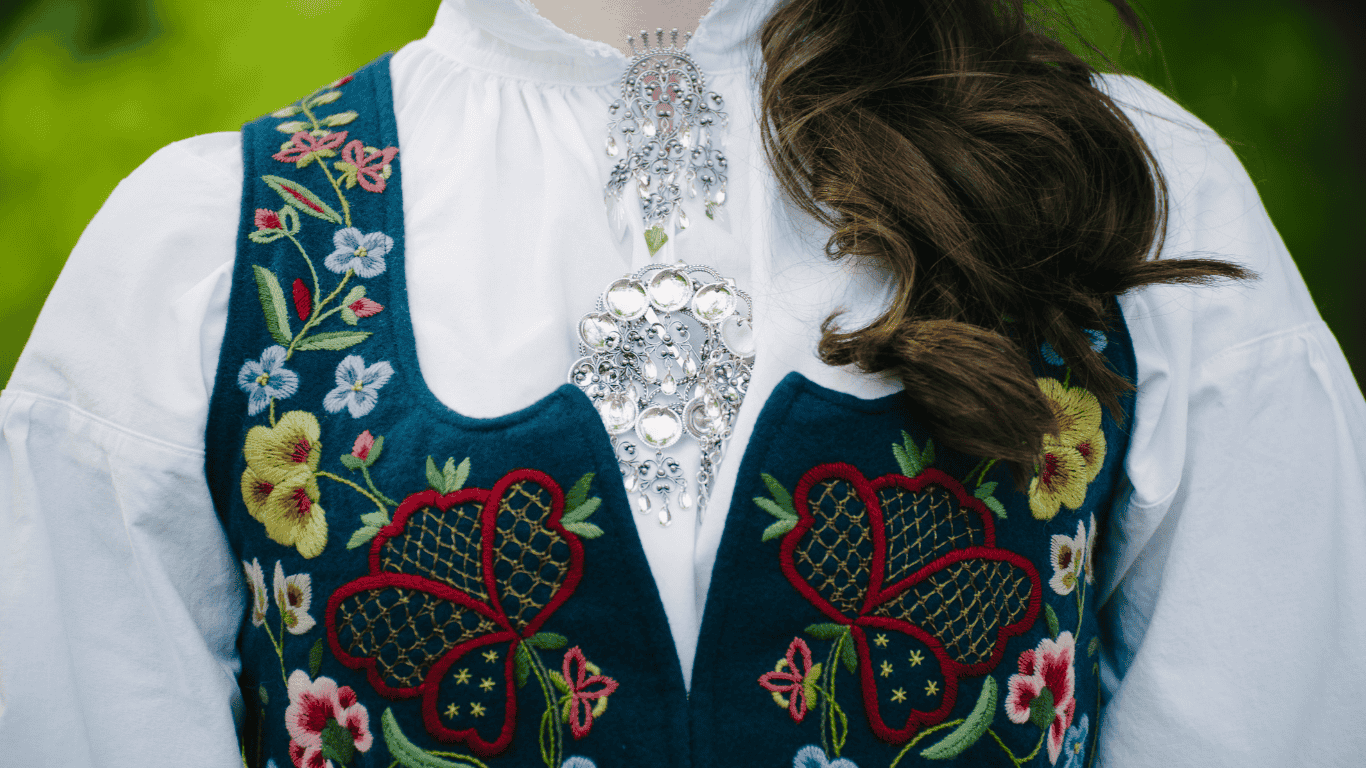 A Norwegian national costume made of wool. The dress is deep blue with colourful embroideries of floral patterns.
